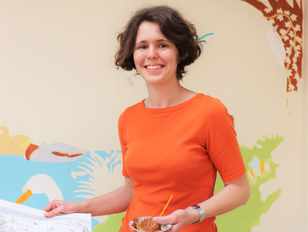 Photo of children's illustrator Emma Metcalfe colouring a drawing by hand with pencils